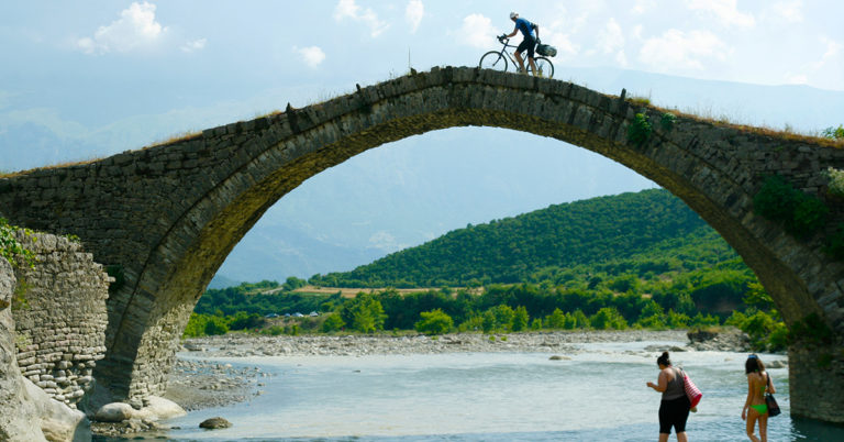 Syklist over steinbro i Albania