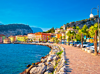 Strandpromenaden i Torbole ved Gardasjøen, med utsikt over sjøen og Brenta-Dolomittene i bakgrunnen | Expa Travel