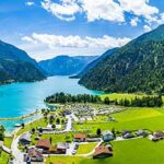 Lite bilde av alpelandsby med azurblå innsjø - Achensee Lake