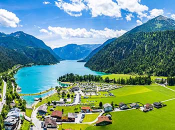Lite bilde av alpelandsby med azurblå innsjø - Achensee Lake